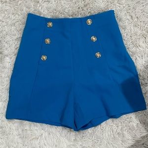 Shorts made of linen blend fabric. High waist with gold buttons